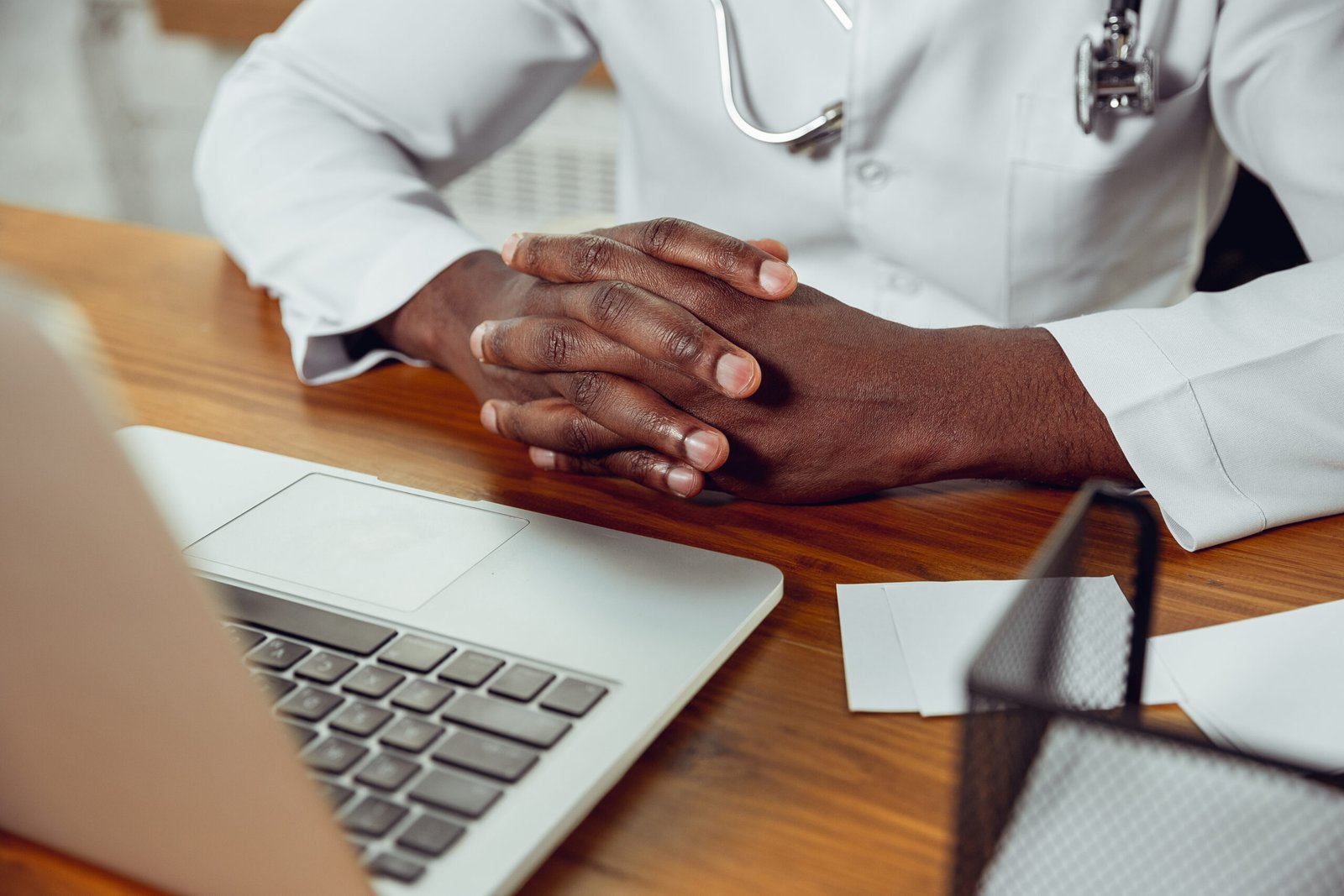 africanamerican doctor consulting patient working cabinet close up scaled